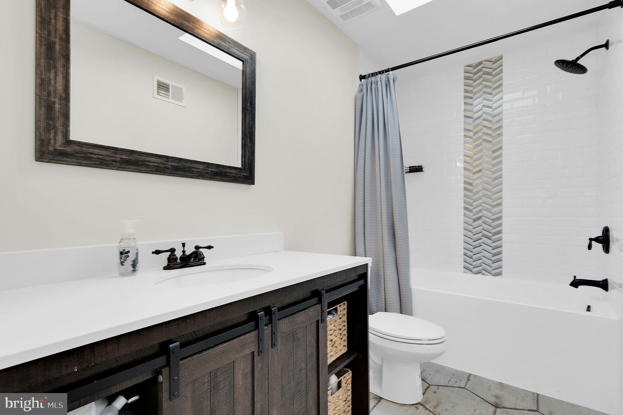 2919 Davidsonville Road Davidsonville, MD 21035 - Photo 38 of 63 a bathroom with a sink vanity mirror and toilet