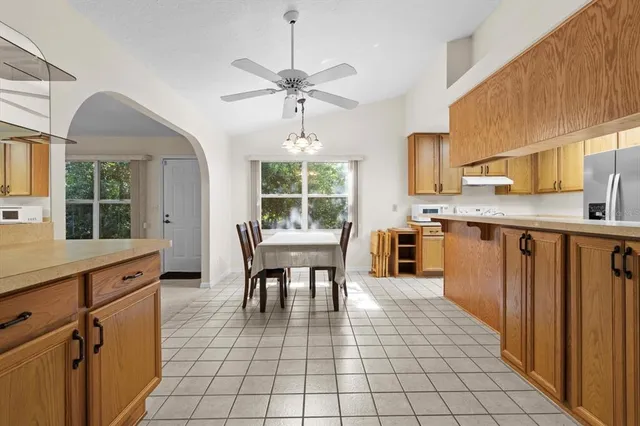 a kitchen with stainless steel appliances granite countertop a refrigerator and a stove top oven