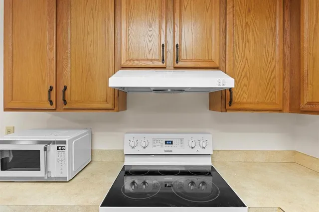 a kitchen with kitchen island a counter top space wooden floor and stainless steel appliances