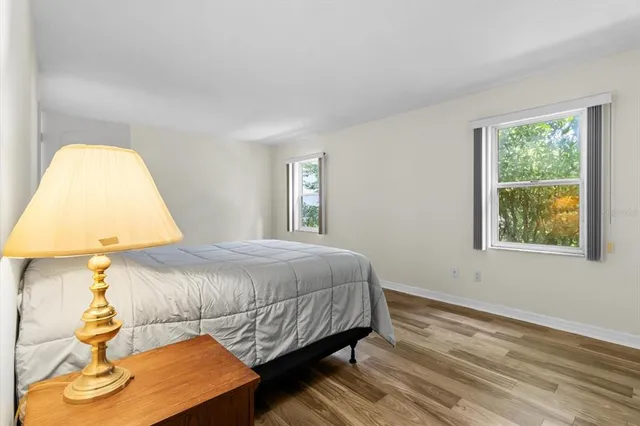 a spacious bedroom with a bed and a lamp