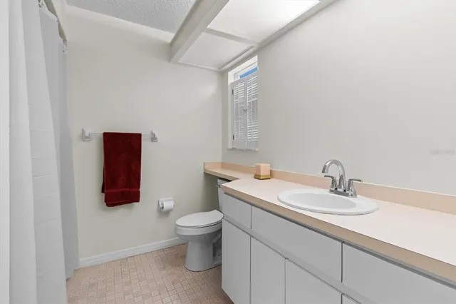 a bathroom with a granite countertop sink mirror vanity and toilet