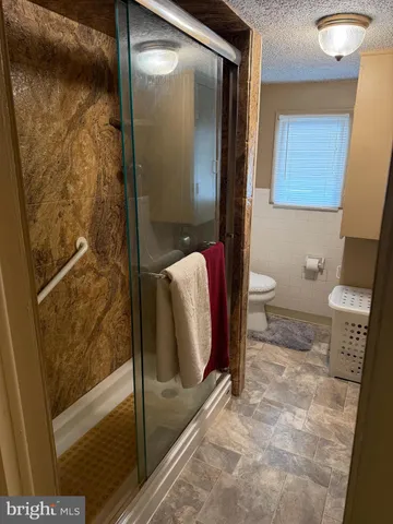 a bathroom with a toilet and a shower