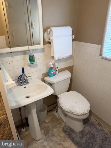 a bathroom with a sink a toilet and mirror