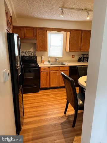 a kitchen with a wooden floor and a refrigerator