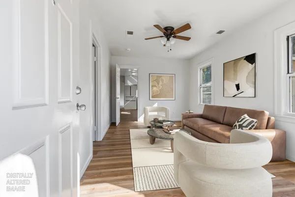 a living room with furniture and a wooden floor
