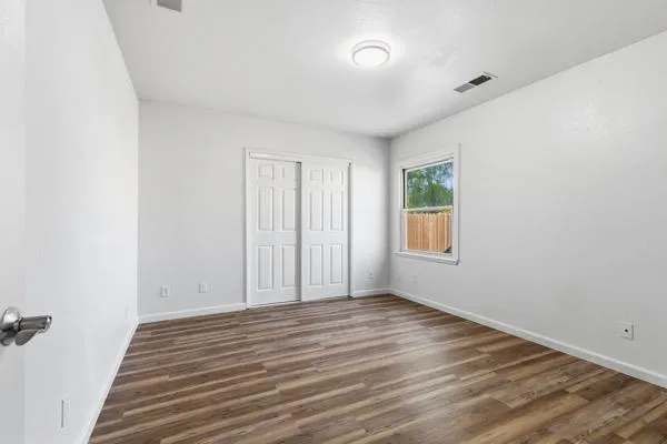 a view of a room with wooden floor and window