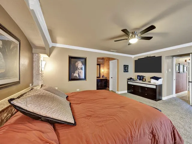 a bedroom with a large bed and a chandelier