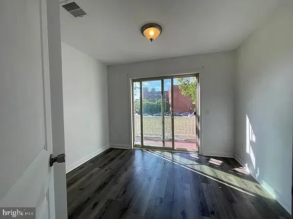 a living room with hardwood floor and window