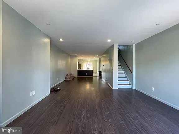 a view of a room with wooden floor staircase and a living room