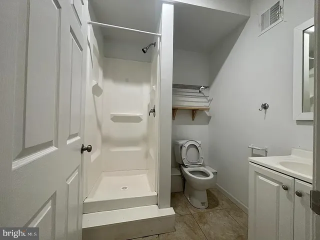 a bathroom with a toilet and a shower
