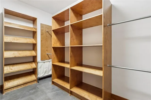 a spacious bedroom with a large bed a chandelier and windows