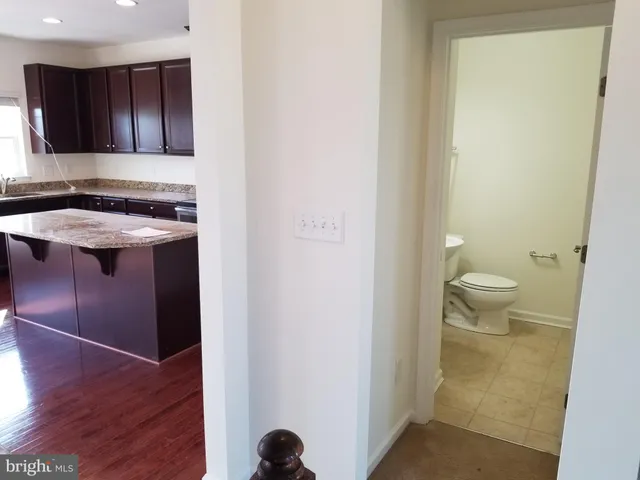 a kitchen with stainless steel appliances granite countertop wooden cabinets a stove a sink and a refrigerator