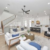 a living room with furniture kitchen view and a chandelier