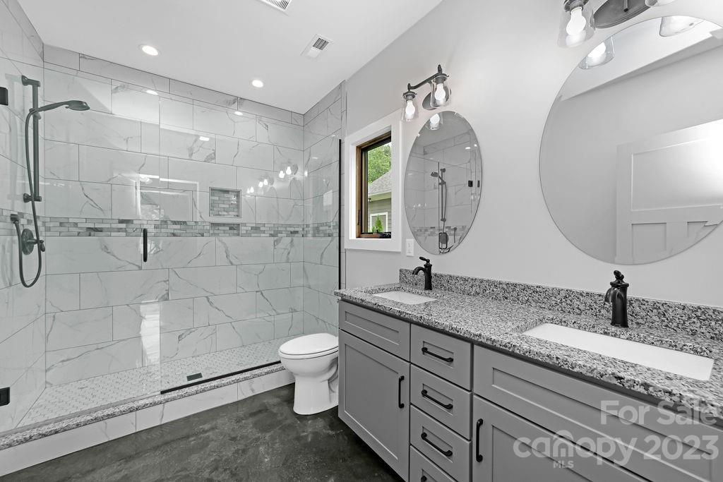 183 Neely Road Brevard, NC 28712 - Photo 24 of 44 a bathroom with a granite countertop sink mirror and toilet