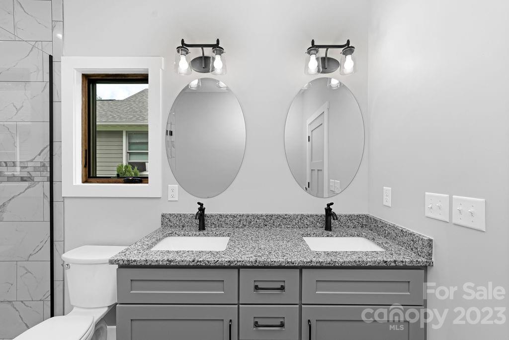 183 Neely Road Brevard, NC 28712 - Photo 25 of 44 a bathroom with a granite countertop double vanity sinks and a mirror