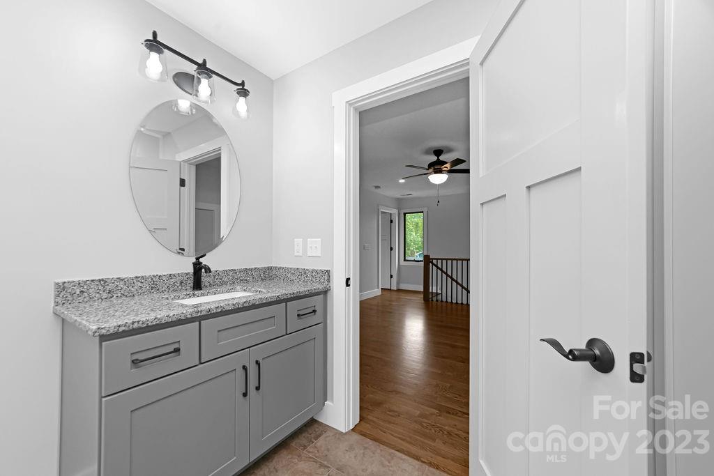 183 Neely Road Brevard, NC 28712 - Photo 34 of 44 a en suite bathroom with a granite countertop sink and a mirror