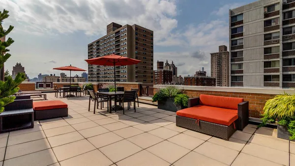 an outdoor sitting area with a couch and an umbrella