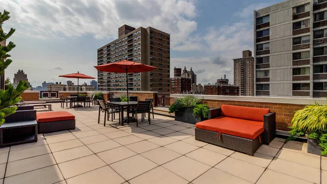 an outdoor sitting area with a couch and an umbrella