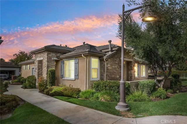 a front view of a house with a yard and potted plants