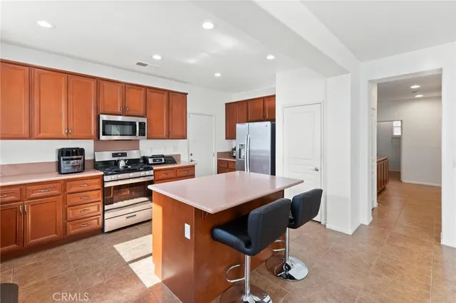 a kitchen with a sink a counter top space stainless steel appliances and cabinets