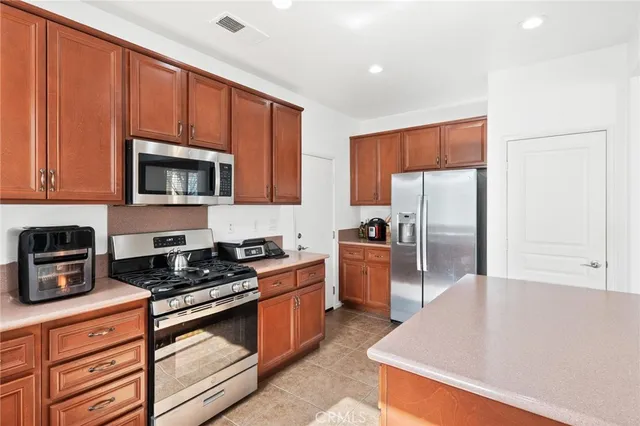 a kitchen with stainless steel appliances granite countertop a refrigerator a stove top oven a sink and dishwasher