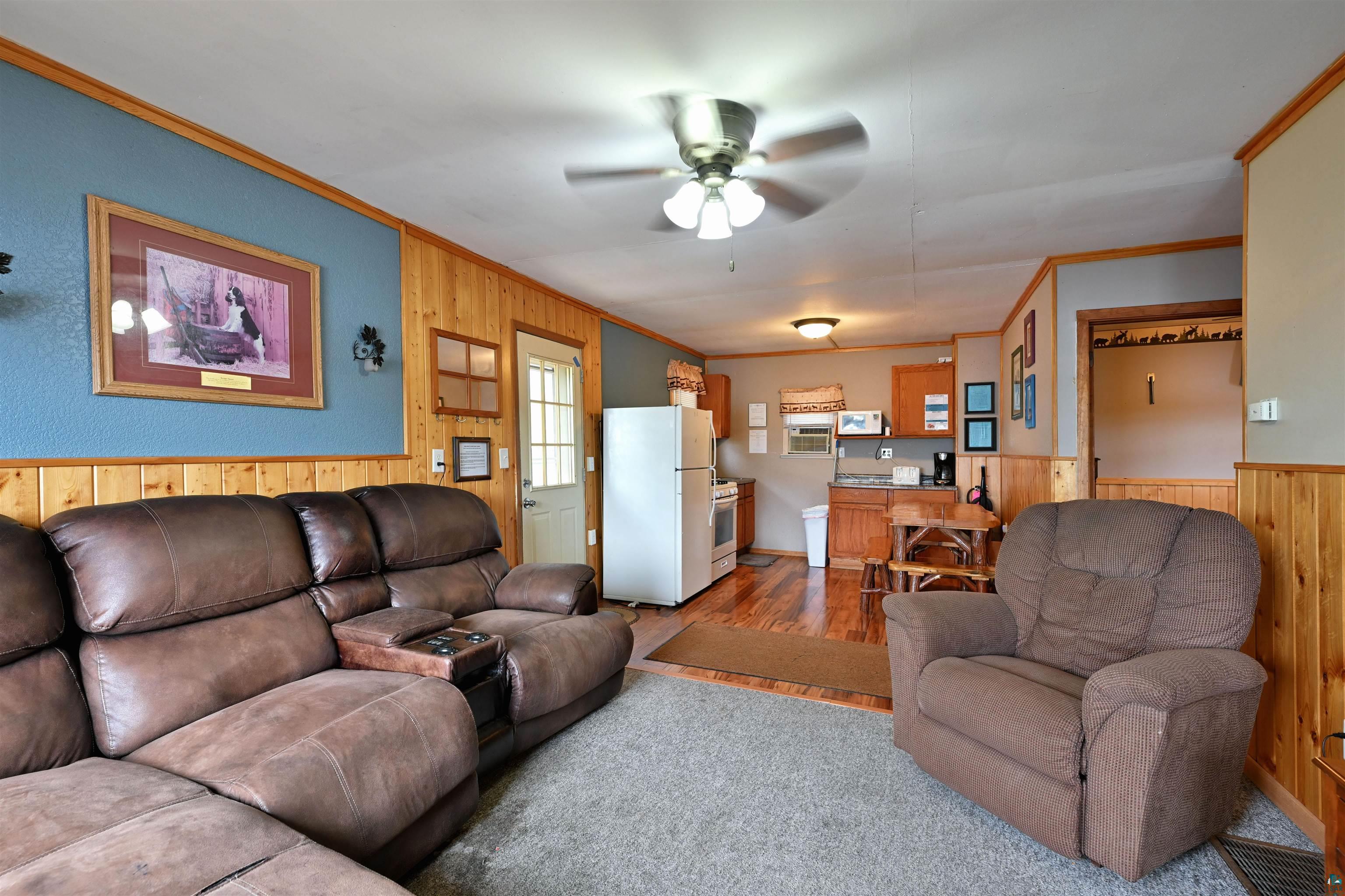 6833 View Point Lodge Road Gordon, WI 54838 - Photo 15 of 40 Living room with wood walls, ornamental molding, wainscoting, a ceiling fan, and wood finished floors