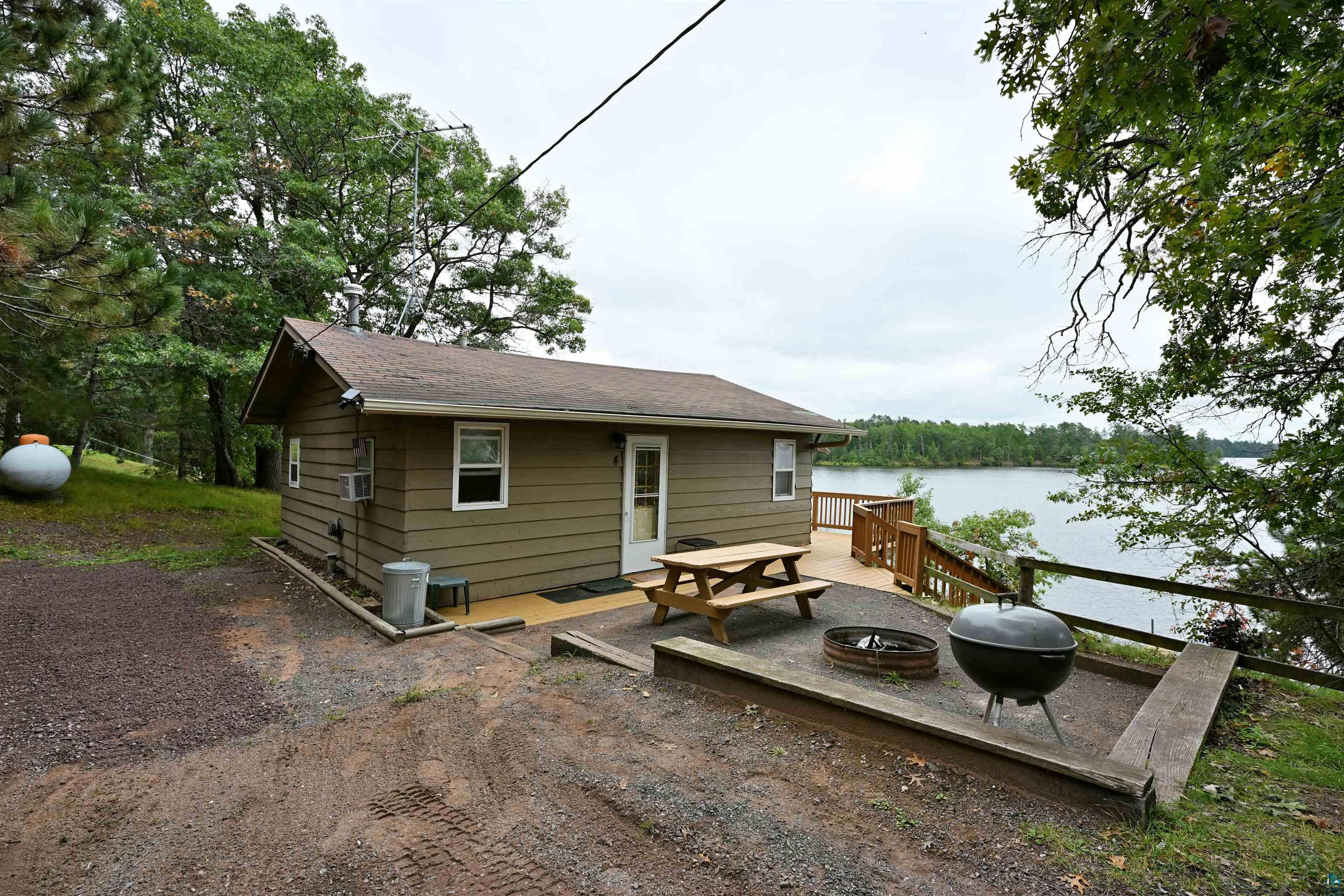 6833 View Point Lodge Road Gordon, WI 54838 - Photo 9 of 40 Rear view of property featuring a deck with water view and an outdoor fire pit