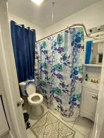 a bathroom with a toilet and shower curtain