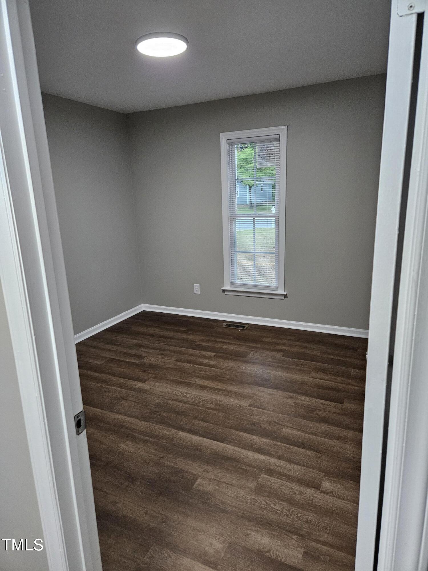 1629 Beverly Road Rocky Mount, NC 27801 - Photo 11 of 13 an empty room with wooden floor and window