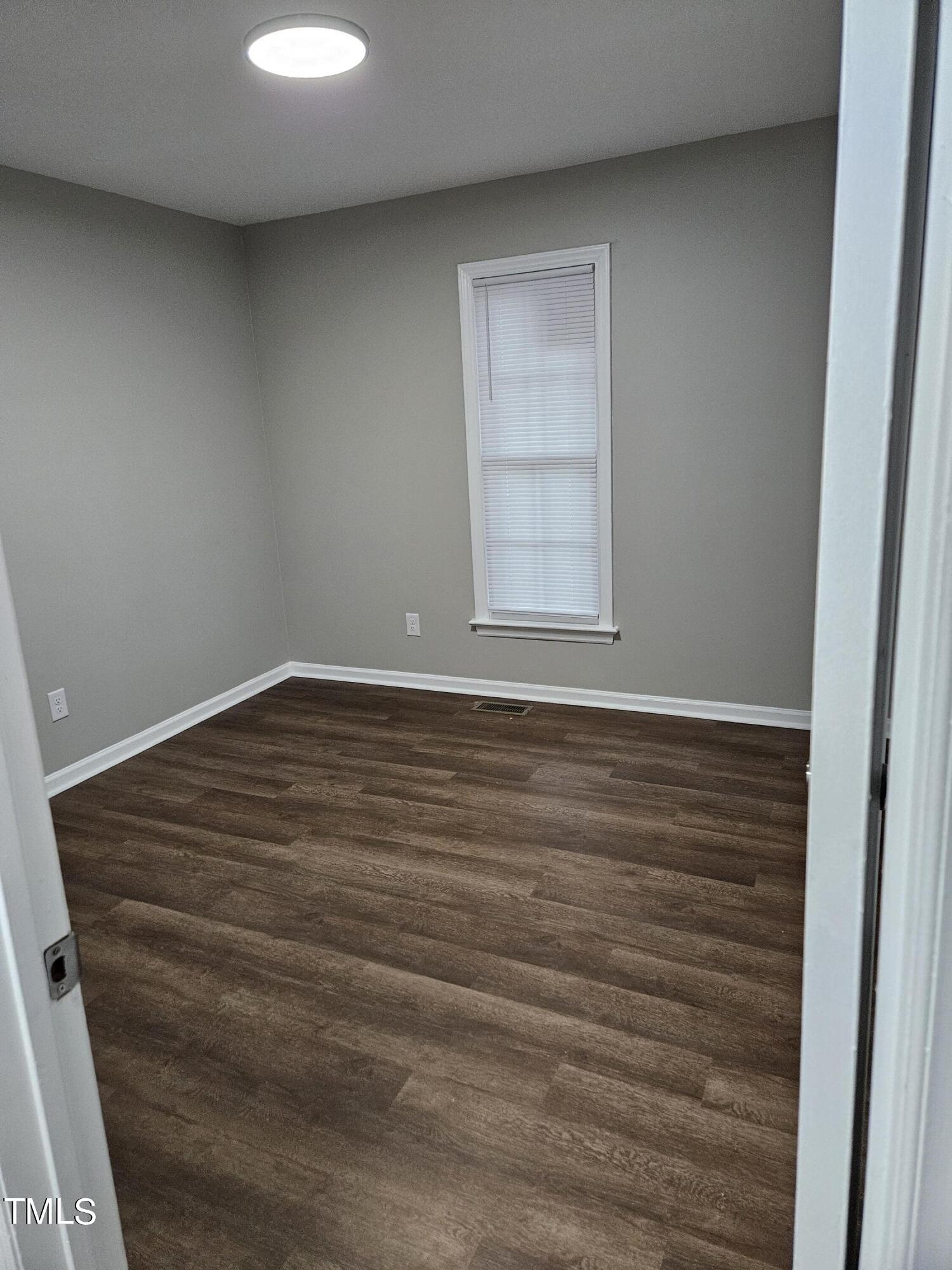1629 Beverly Road Rocky Mount, NC 27801 - Photo 12 of 13 an empty room with wooden floor and windows