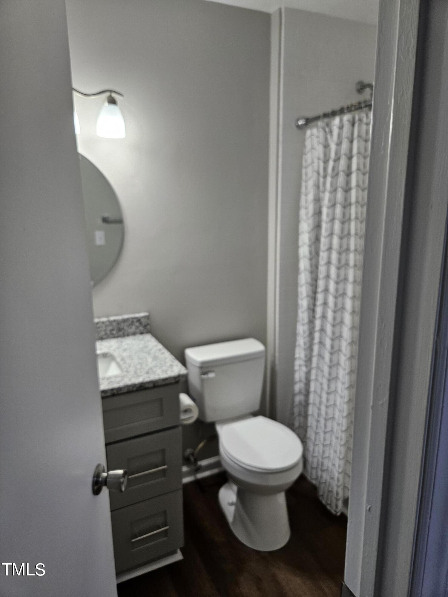 1629 Beverly Road Rocky Mount, NC 27801 - Photo 8 of 13 a white toilet sitting next to a shower curtain