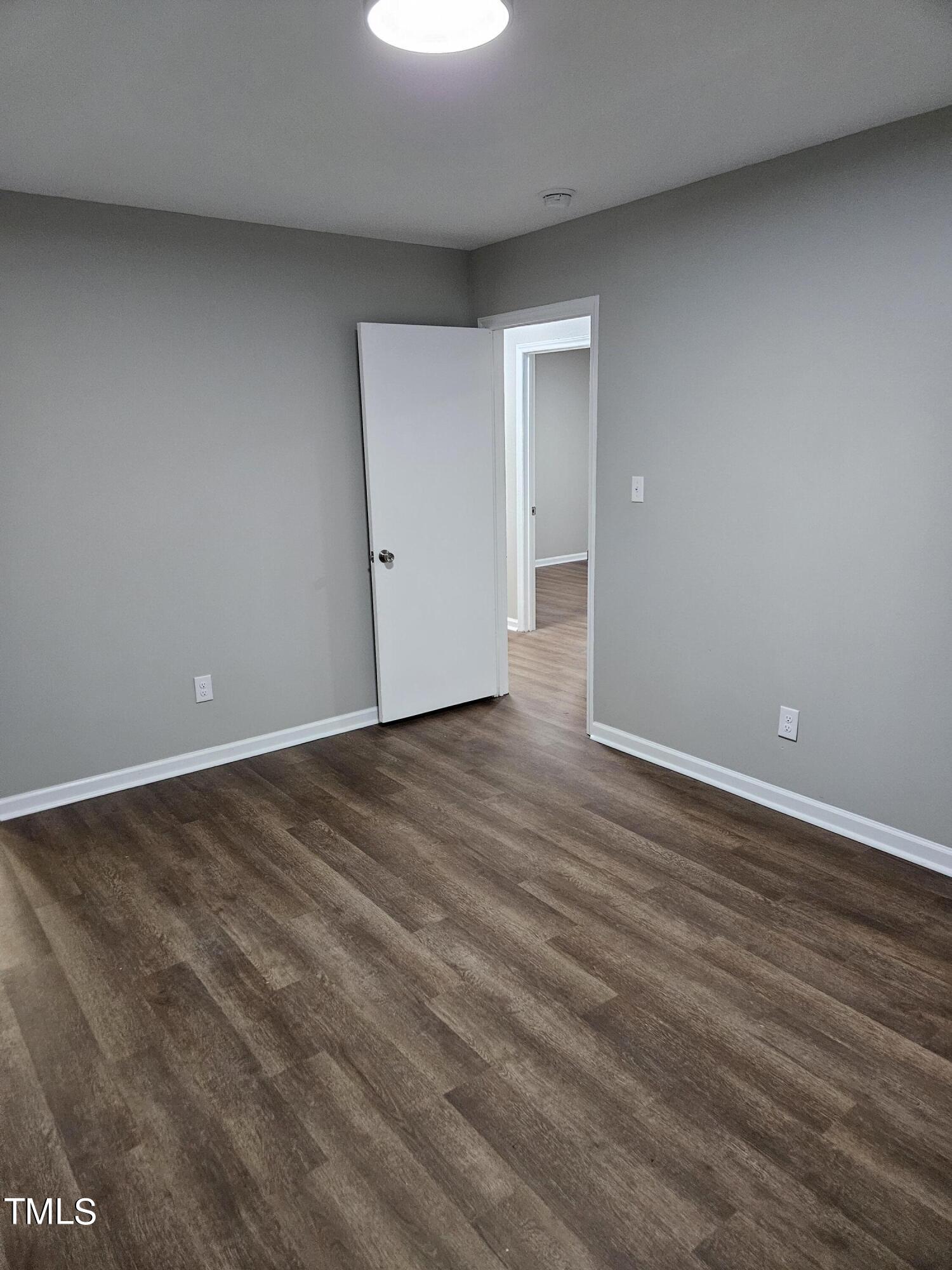 1629 Beverly Road Rocky Mount, NC 27801 - Photo 10 of 13 a view of an empty room with wooden floor & window
