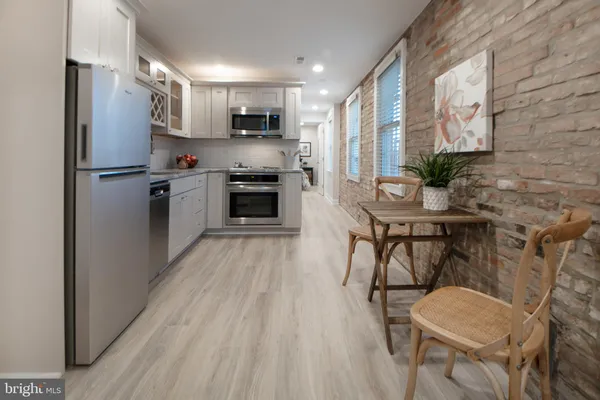 a kitchen with stainless steel appliances white cabinets and a refrigerator