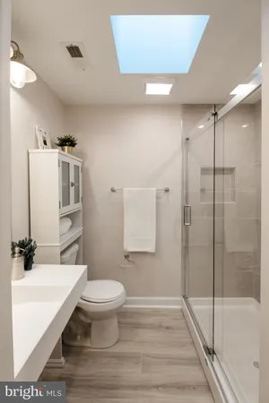 a bathroom with a sink a toilet and shower