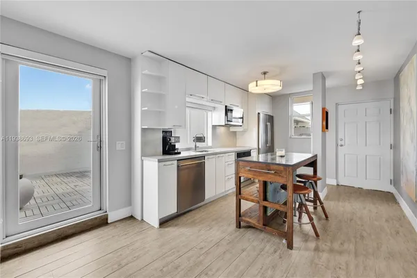 a kitchen with a table chairs refrigerator and microwave