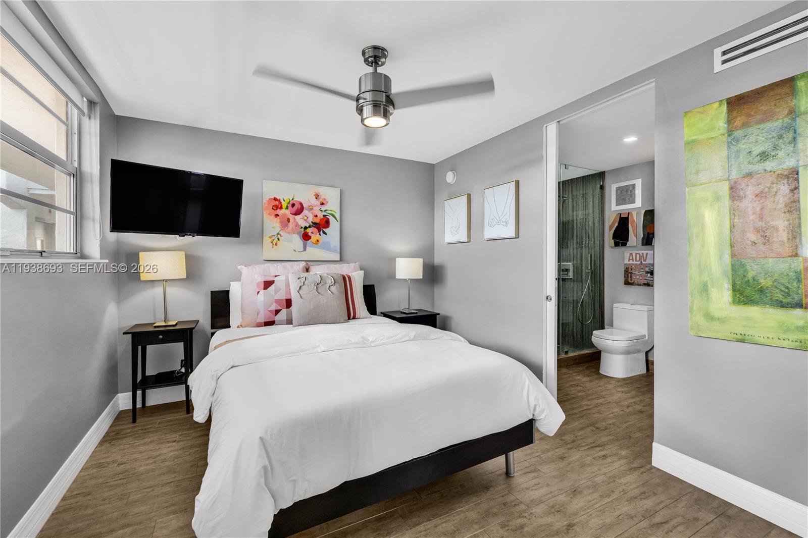 680 Northeast 64th Street, Unit APH2 Miami, FL 33138 - Photo 4 of 24 a bedroom with a large bed a flat screen tv and a window