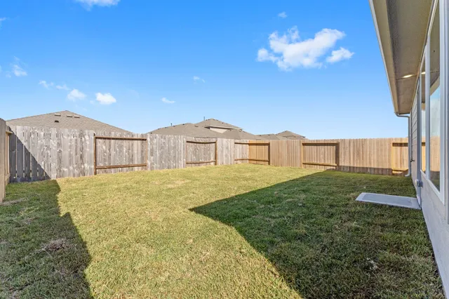 a view of backyard with wooden fence