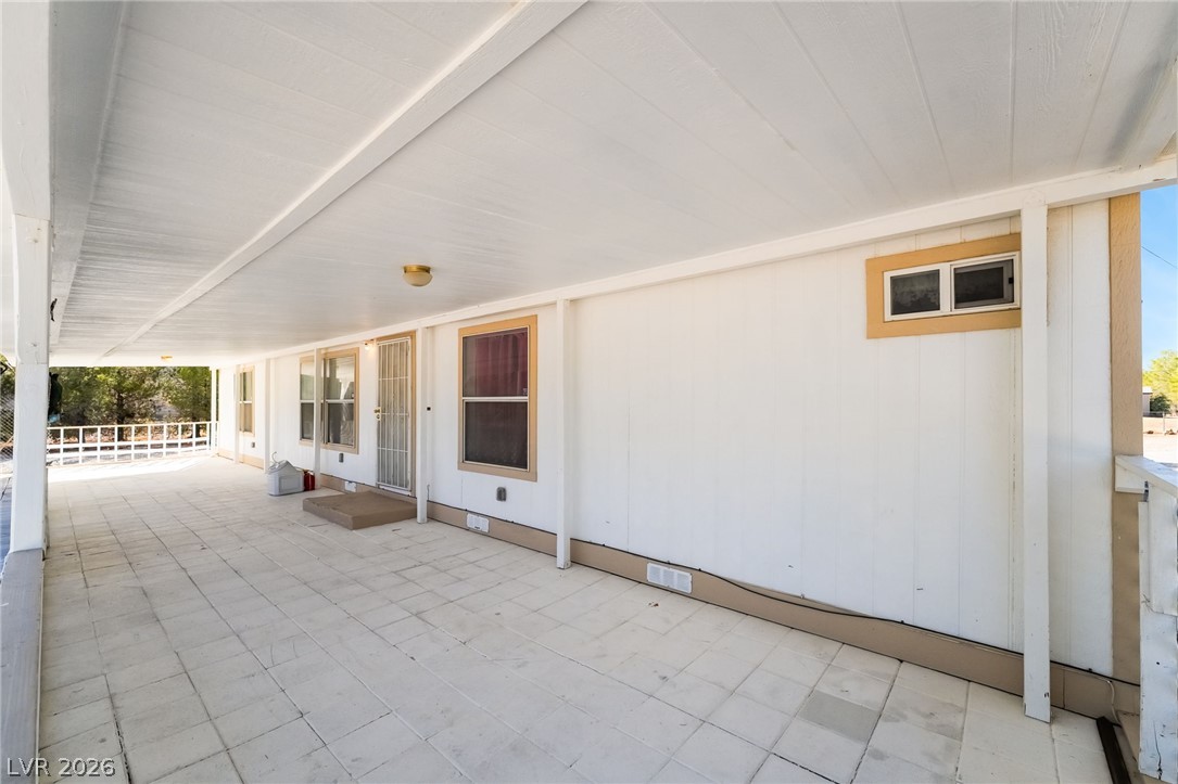 1551 West Wilson Road Pahrump, NV 89048 - Photo 9 of 68 A long covered porch with tile flooring extends along the side of the home.