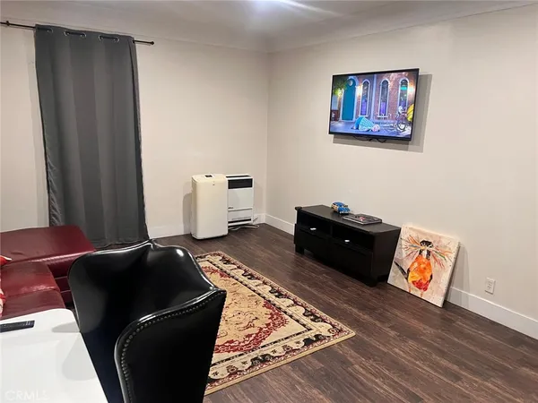 a living room with a bed and wooden floor