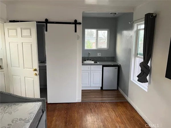 a kitchen with stainless steel appliances a refrigerator and wooden floor