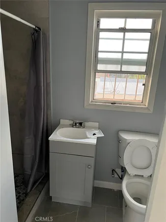 a bathroom with a sink toilet and window
