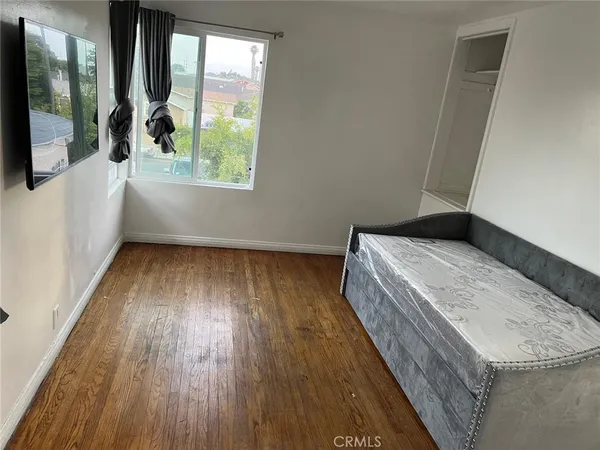 a view of a room with wooden floor and a window