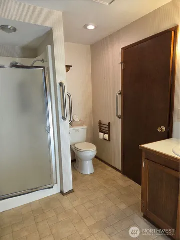 a bathroom with a granite countertop sink toilet and shower
