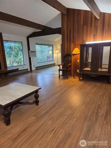 a living room with furniture pool table wooden floor and a window