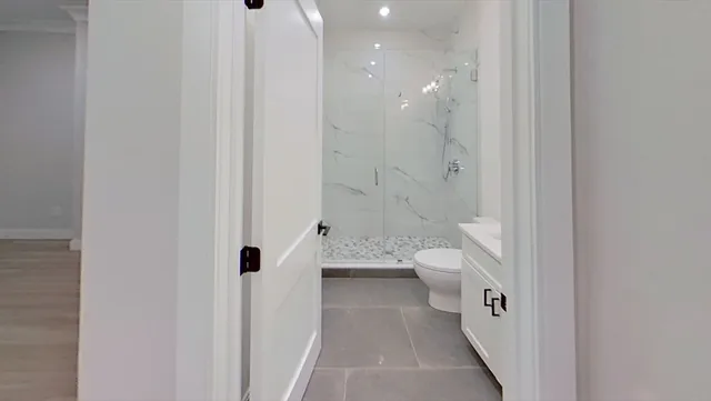 a bathroom with a granite countertop sink a toilet and a shower