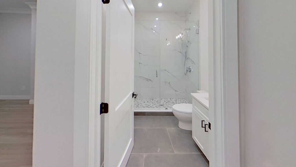 47 Englewood Avenue, Unit 5 Boston, MA 02135 - Photo 7 of 7 a bathroom with a granite countertop sink a toilet and a shower