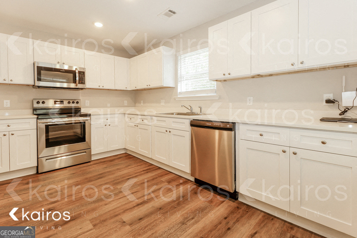 153 Cottage Grove Road Brunswick, GA 31525 - Photo 6 of 16 a kitchen with granite countertop white cabinets and white appliances