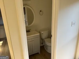 a bathroom with a granite countertop toilet and a sink