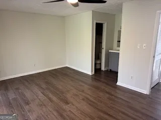 a view of a room with wooden floor and a bathroom