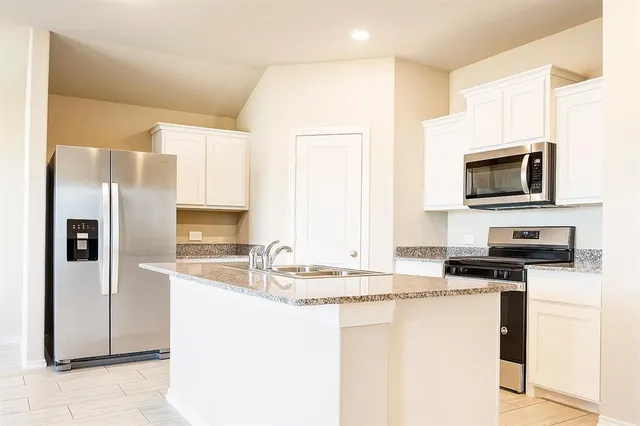 a kitchen with kitchen island a sink stainless steel appliances and cabinets